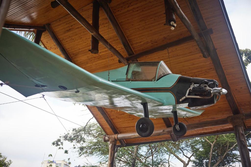 a small green airplane hanging from a wooden ceiling at Aero Club of East Africa in Nairobi