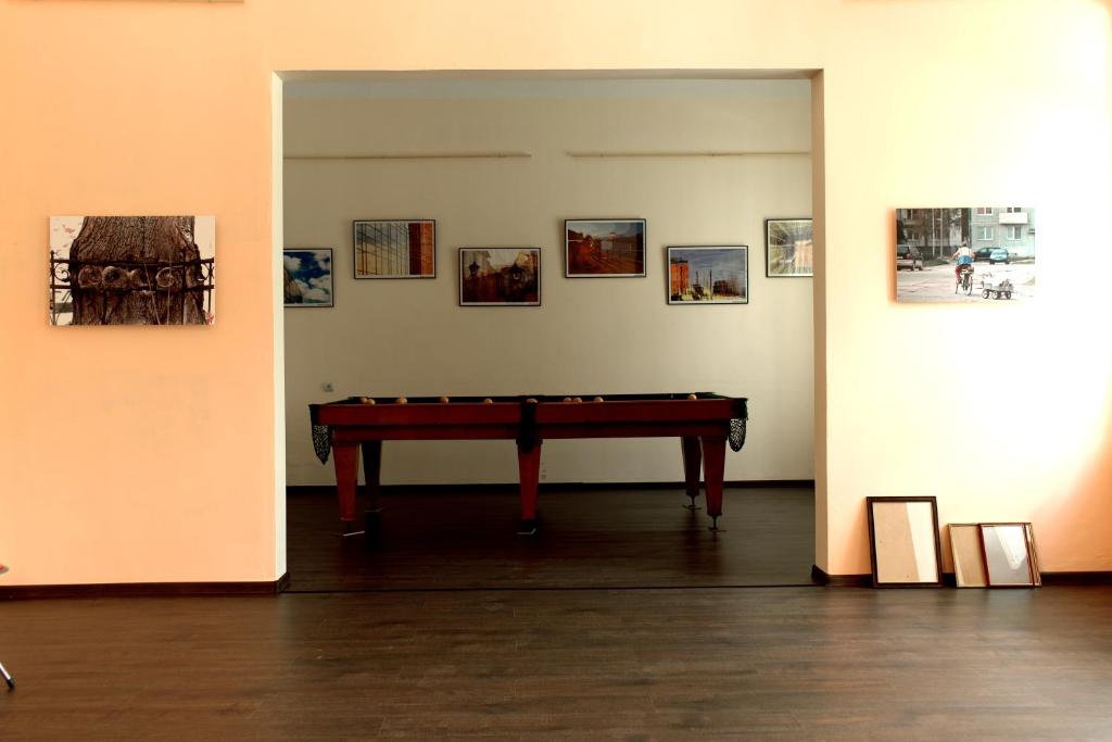 een tafeltennistafel in een kamer met foto's aan de muur bij STONE GARDEN 2 in Liepāja