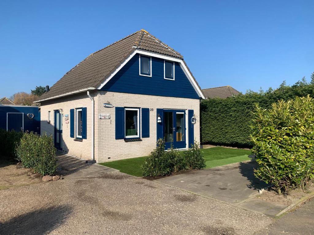 una casa azul y blanca con entrada en Vakantiewoning Ouddorp - kindervriendelijk, en Ouddorp