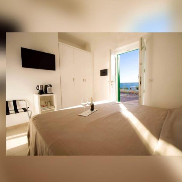 a bedroom with a bed with a wine glass on it at Country House “ Il Mandorlo” in Acciaroli