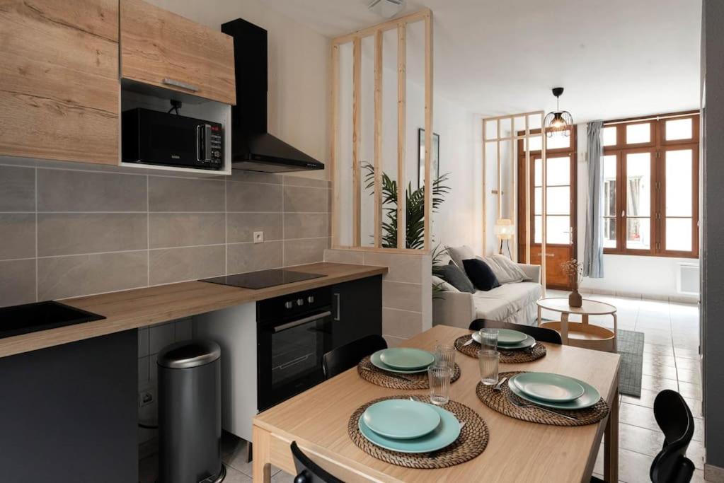 d'une cuisine et d'un salon avec une table et des assiettes. dans l'établissement The Family Home, à Carcassonne