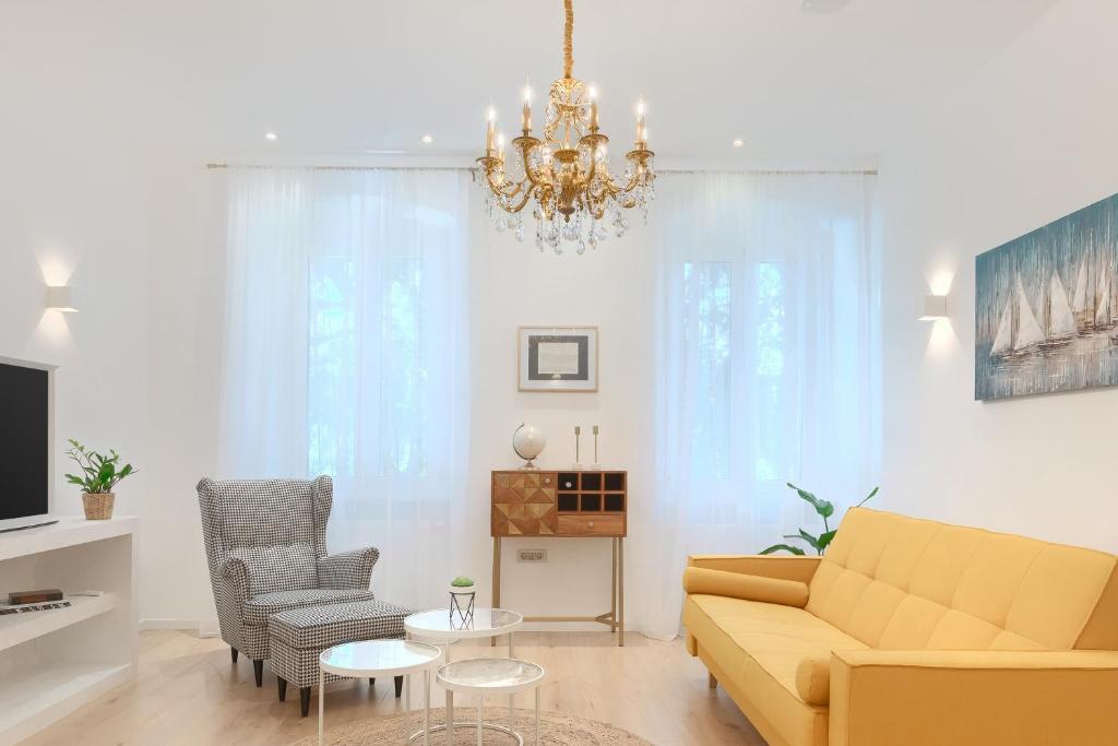 a living room with a couch and a chandelier at Calafati Apartment with free private parking in Rijeka