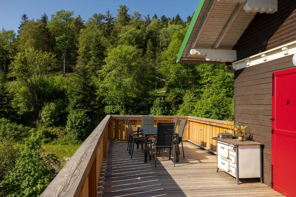 a deck with a table and chairs on it at Eden du Boenlesgrab in Lautenbach