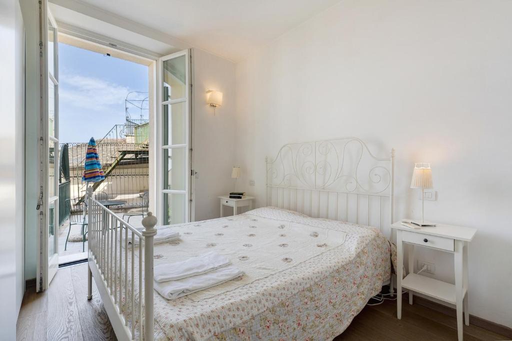 Biała sypialnia z łóżkiem i balkonem w obiekcie Casa Mare w mieście Levanto
