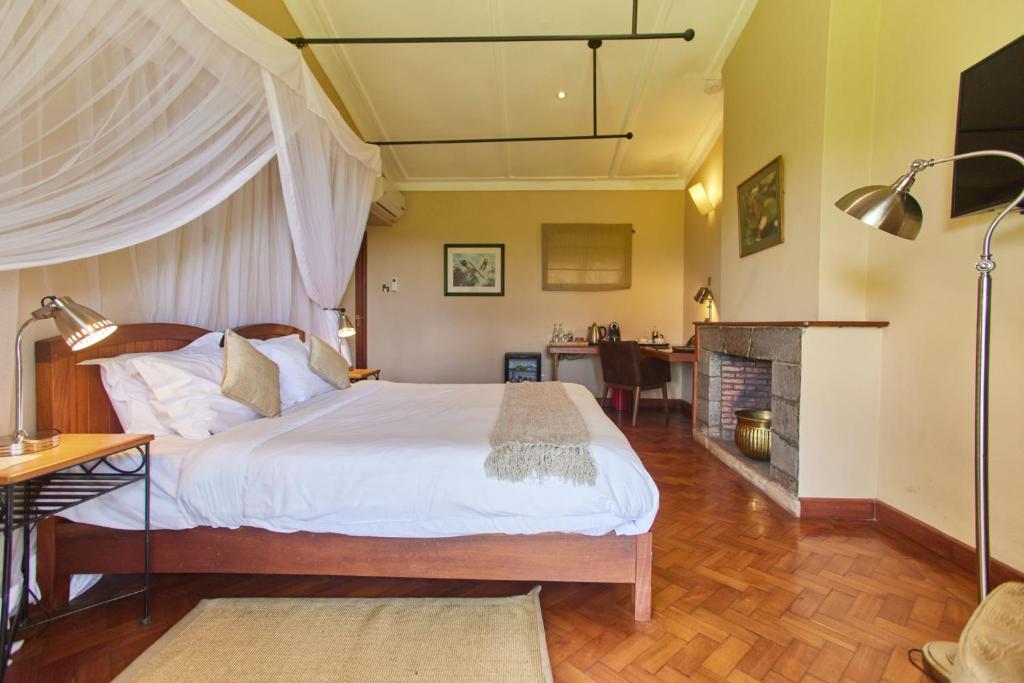 a bedroom with a large bed and a fireplace at Aero Club of East Africa in Nairobi