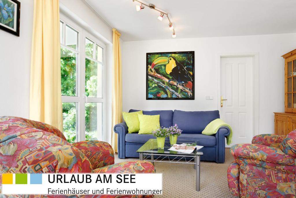 sala de estar con sofá azul y almohadas amarillas en Villa Kurpark Bad Saarow, en Bad Saarow
