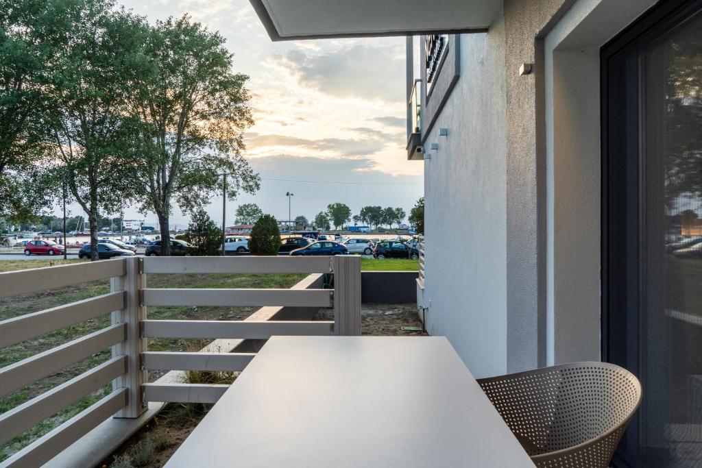 a white table on a balcony with a view of a parking lot at NERO SEASCAPE SUITES in Fanari