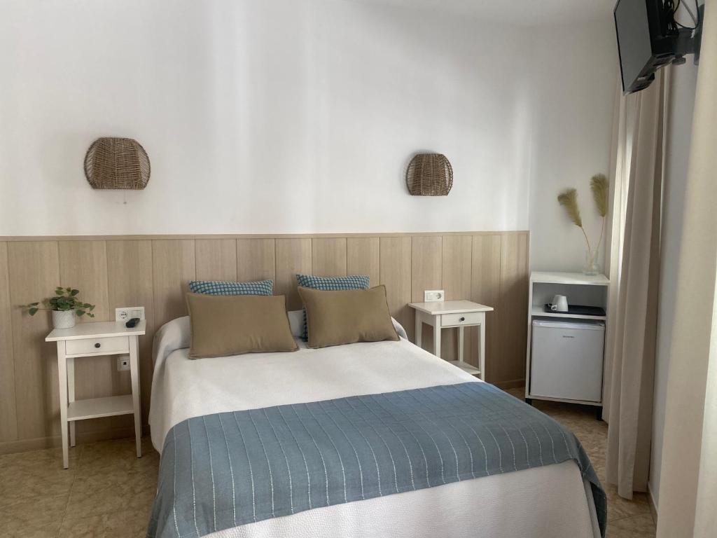 1 dormitorio con 1 cama grande y 2 mesas en Hostal Andalucia en Nerja