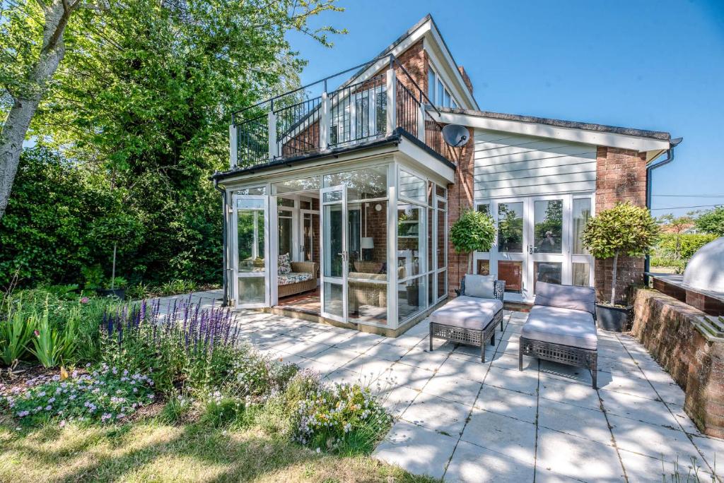 a glass house with a balcony and a patio at The Shealing, Waldringfield (Air Manage Suffolk) in Waldringfield