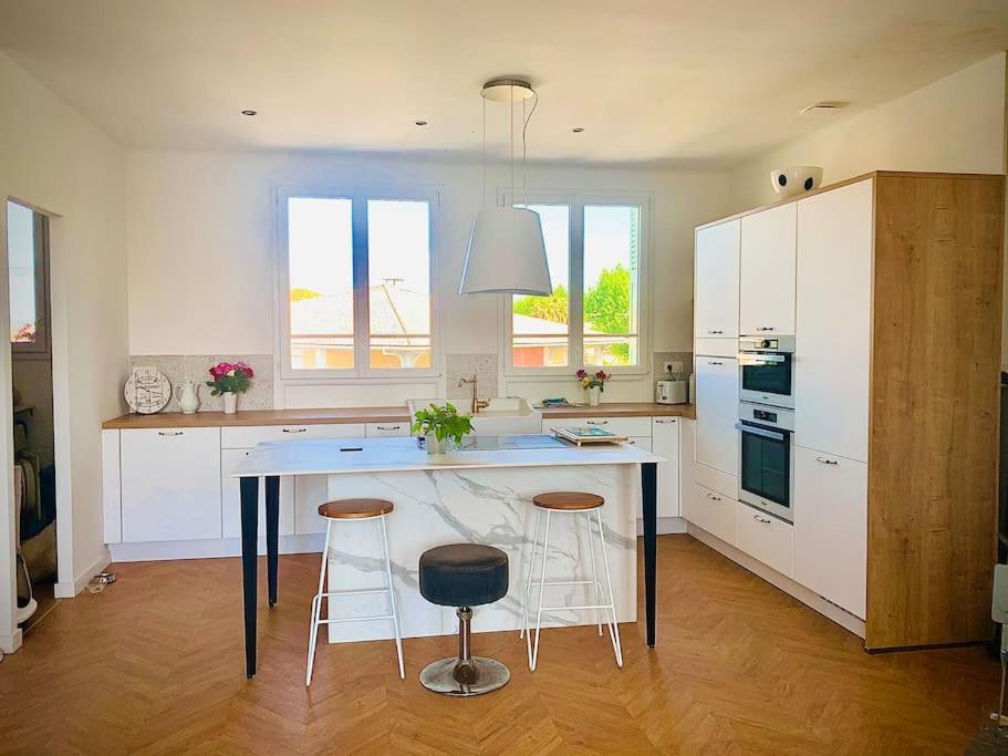 une cuisine avec une table et deux tabourets dans l'établissement Grand T3 Fréjus base nature, à Fréjus