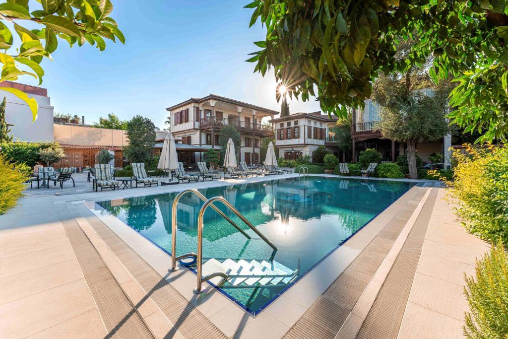 una gran piscina con sillas y sombrillas en RuinAdalia Hotel - Adult Only, en Antalya