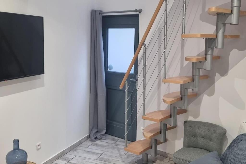 - un escalier dans le salon doté d'un canapé et d'une télévision dans l'établissement Air Cosy 3 Valenciennes gare prostitution refusée, à Valenciennes