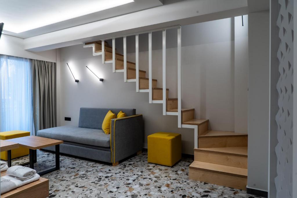 a living room with a staircase and a couch at NERO SEASCAPE SUITES in Fanari