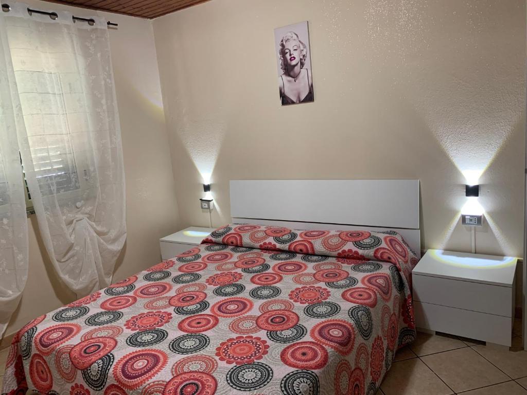 1 dormitorio con 1 cama y 2 mesitas de noche en Casa vacanze Tilly, en Pannaconi