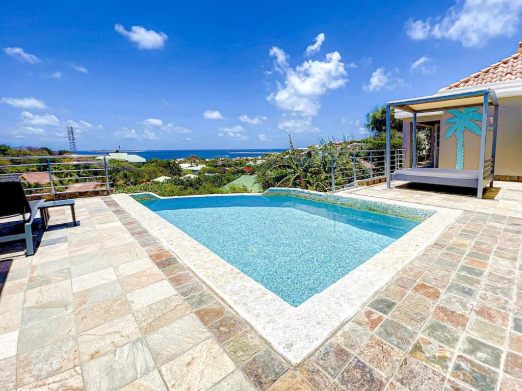une piscine avec vue sur l'océan dans l'établissement Villa Caraibe Sea 5 min walk to Orient Bay beach, à La Baie-Orientale