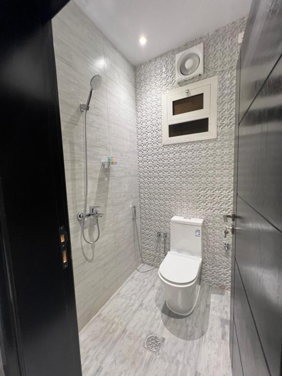 شقة بغرفتي نوم وصالة جلوس في المدينة المنورة: حمام مع مرحاض أبيض ودش
