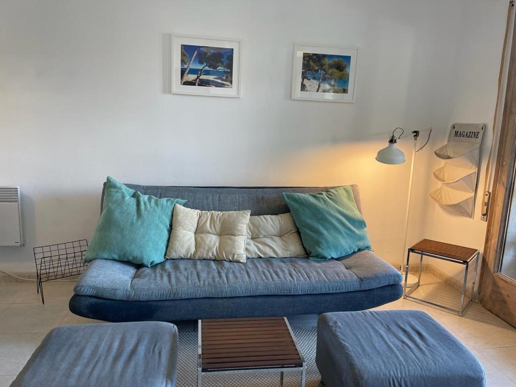 Apartamento en el centro de Miami Platja 155B - INMO22 في هوسبيتاليت دي لانفنت: غرفة معيشة مع أريكة زرقاء مع وسائد