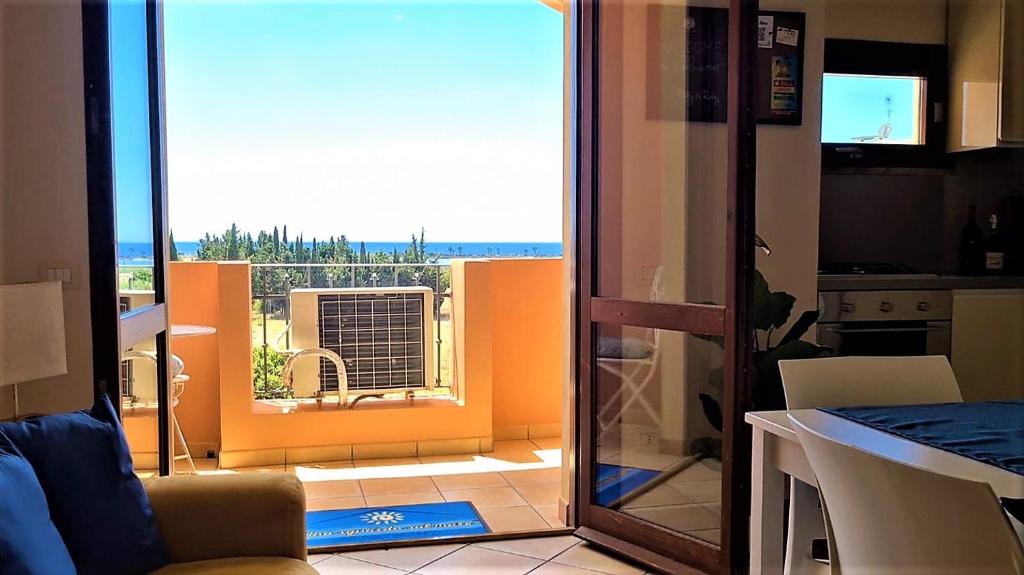 eine Küche mit einer Glasschiebetür, die auf einen Balkon führt in der Unterkunft Uno sguardo sul mare - Apartment - in Quartu SantʼElena