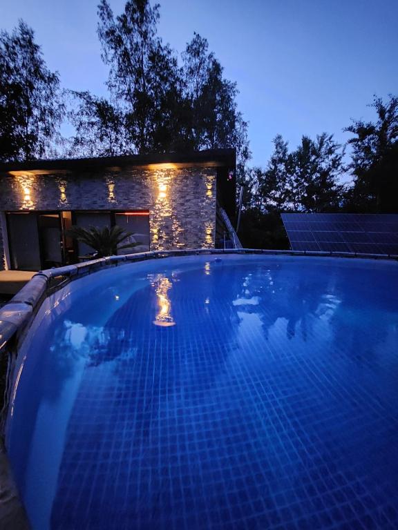 una piscina frente a una casa por la noche en Leśny chillout en Solina