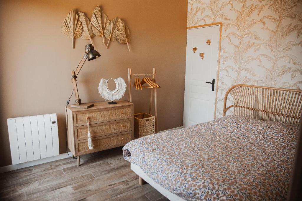 een slaapkamer met een bed en een lamp op een dressoir bij « La Casa Normande » entre Ville & Plages in Esquay-sur-Seulles