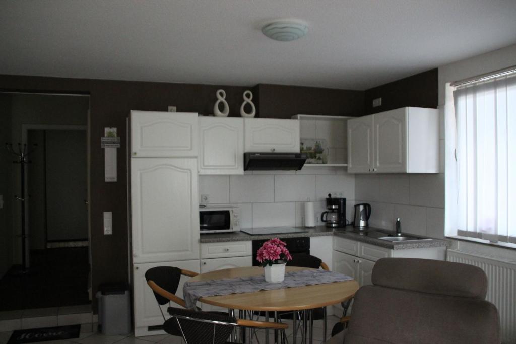 a kitchen with a table and chairs and a dining room at Ferienwohnung Drieling_ 85091 in Ostrhauderfehn