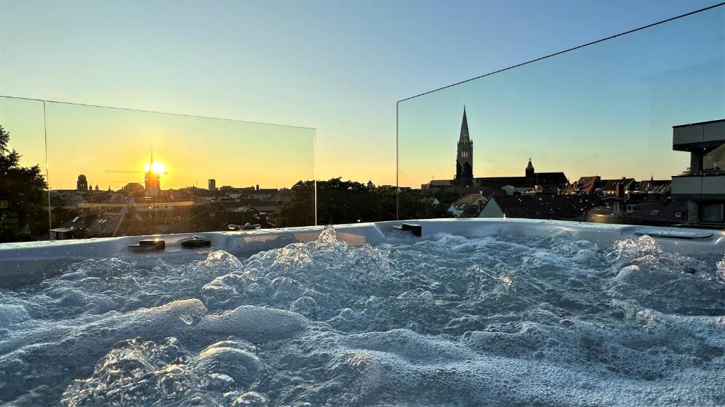 a bath tub filled with water with a view of a city at Historical Luxury Homes - Exclusive Selection in Freiburg im Breisgau