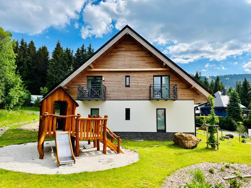 una casa con porche y una casa de madera en Ski Chalet Klínovec, en Loucná pod Klínovcem