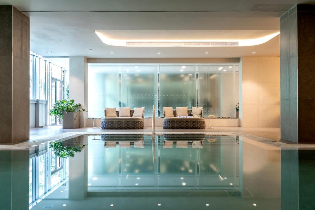 a lobby with a pool in the middle of a building at NissiBlu Beach Resort in Ayia Napa