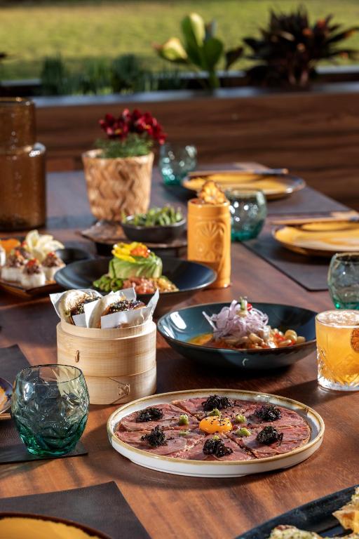 a long wooden table with plates of food on it at NissiBlu Beach Resort in Ayia Napa