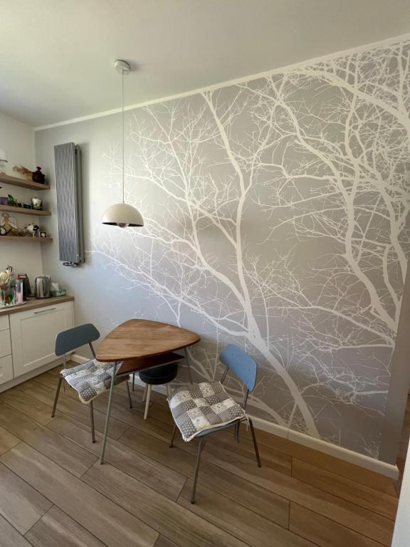 a dining room with a tree mural on the wall at Gdynia Centrum ul. Pomorska in Gdynia