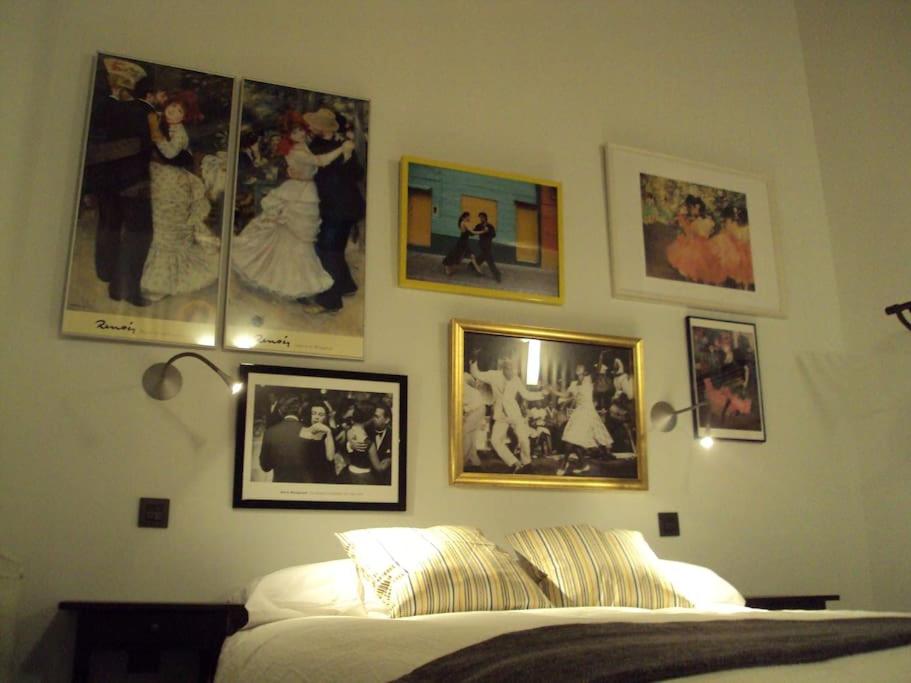 a bedroom with pictures on the wall and a bed at EL BAILE, casa con jacuzzi al lado de Peñafiel in Olmos de Peñafiel