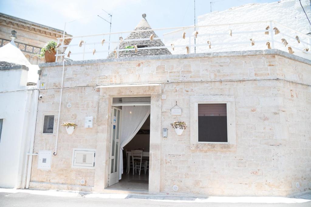 um edifício de tijolos com uma porta com uma mesa em Trullo Dimora Zaccaria em Alberobello