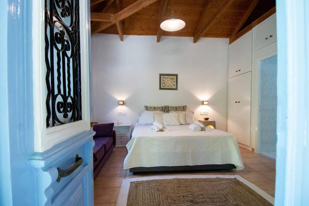 a bedroom with a bed and a couch at Bibelo Holiday Home in Laganas