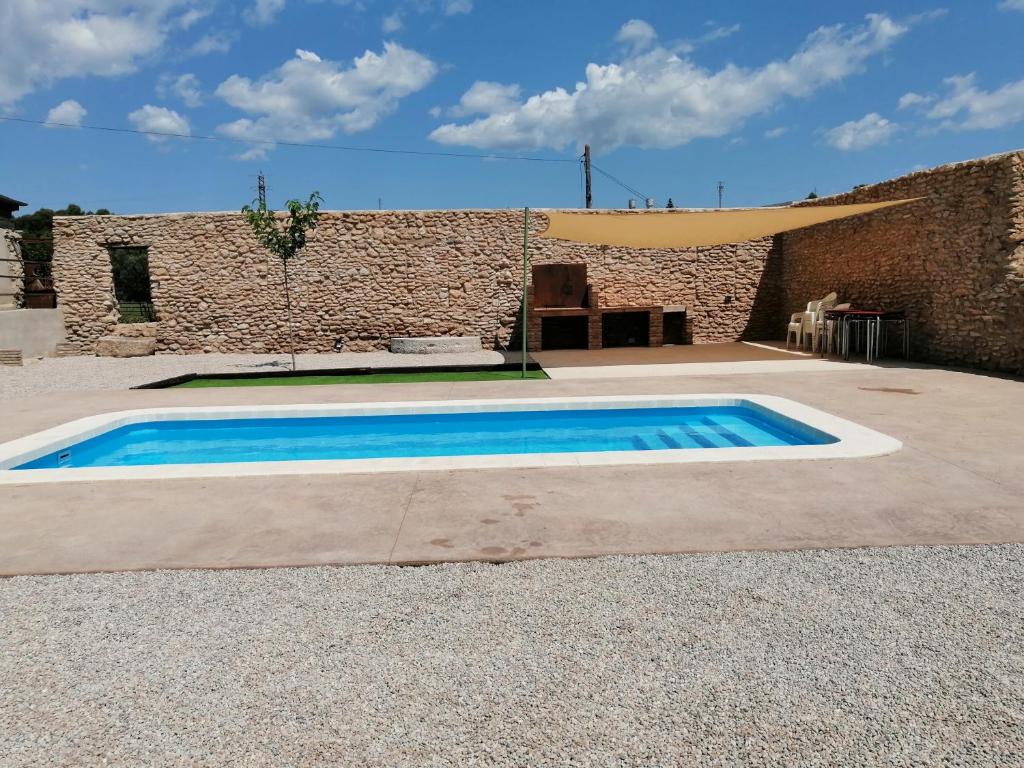 - une piscine en face d'un bâtiment en briques dans l'établissement Casa Rural Moli, à Rosell