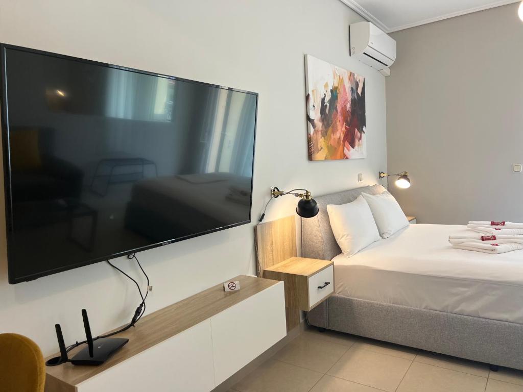 Schlafzimmer mit einem großen Flachbild-TV an der Wand in der Unterkunft City House Comfort 1 in Kalamata