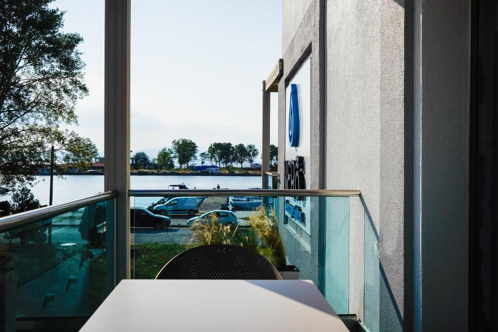 a balcony with a table and a view of the water at NERO SEASCAPE SUITES in Fanari