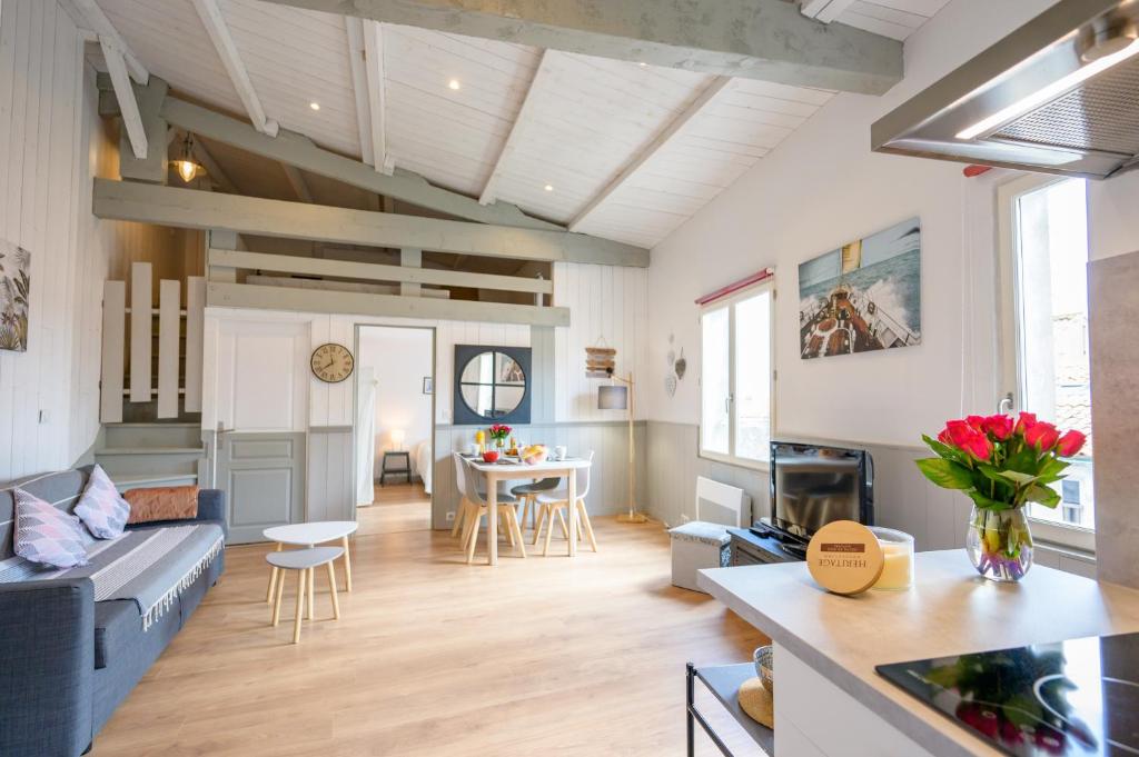 a living room with a couch and a table at Appart le Grignon in Saint-Martin-de-Ré