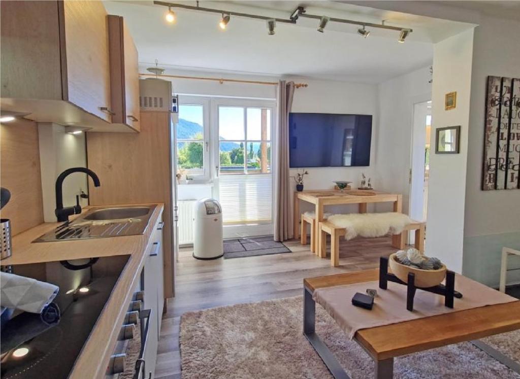 a kitchen and a living room with a table at Appartement Bergsee SUN - am Wildsee - atemberaubende Aussicht in Seefeld in Tirol
