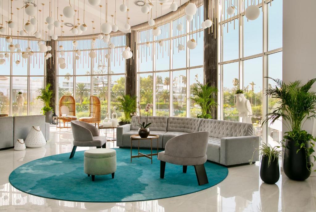 a lobby with a couch and chairs and a table at NissiBlu Beach Resort in Ayia Napa