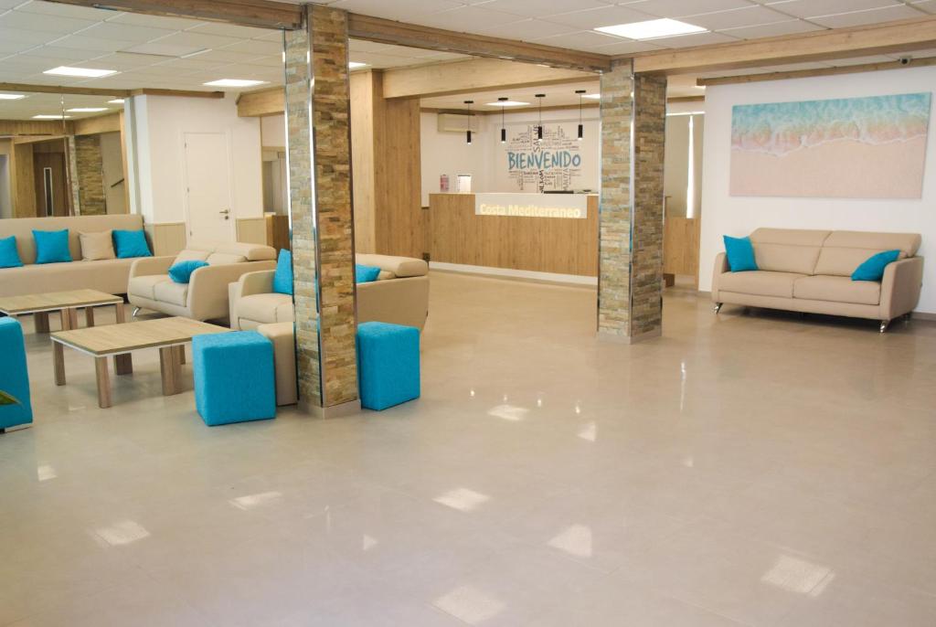 a waiting room with couches and tables in a building at Hotel Costa Mediterraneo in El Arenal