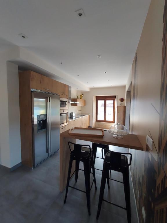 a kitchen with a wooden table and a refrigerator at Casa Rojo in Camariñas