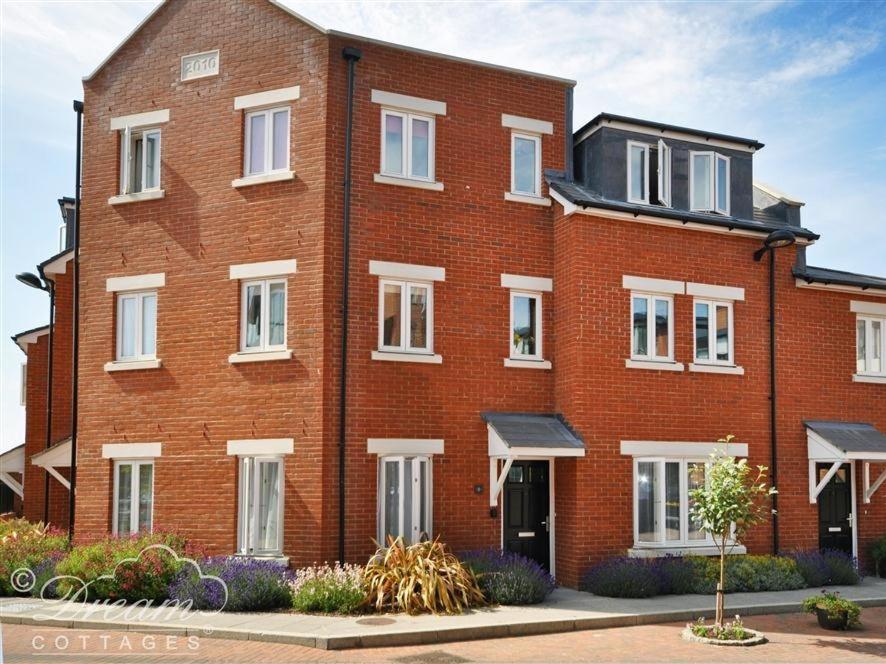 - un grand bâtiment en briques rouges avec des fenêtres blanches dans l'établissement Admiral's Quarter Apartment 5, à Weymouth
