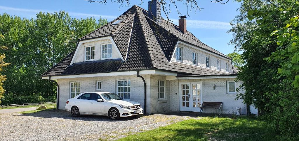 a white car parked in front of a house at FEWO Weissenhäuser Strand in Wasbuck