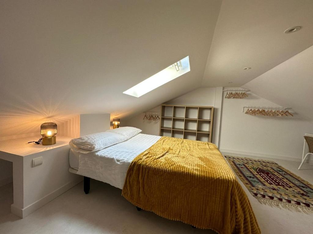 a attic bedroom with a bed and a skylight at Design apartment with garage in Santander
