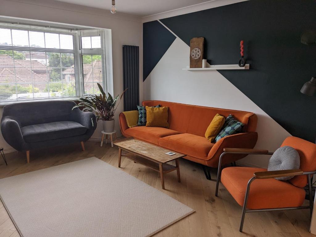 a living room with an orange couch and a chair at Spacious Unique Brighton Home FREE Parking in Brighton & Hove