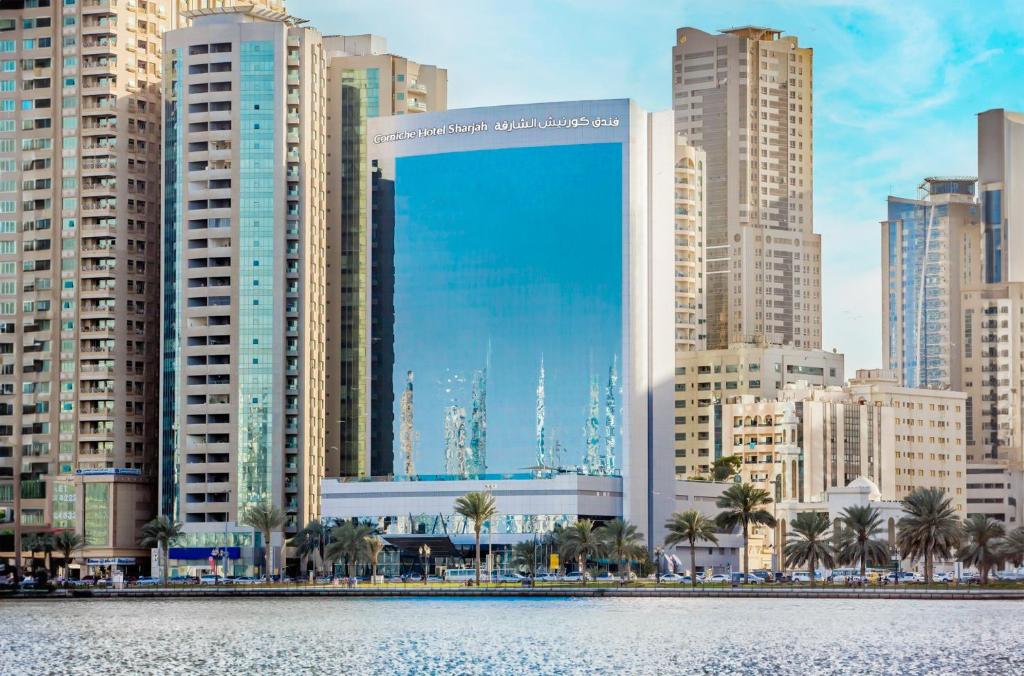 Corniche Hotel Sharjah في الشارقة: اطلالة على مدينة ذات مباني طويلة