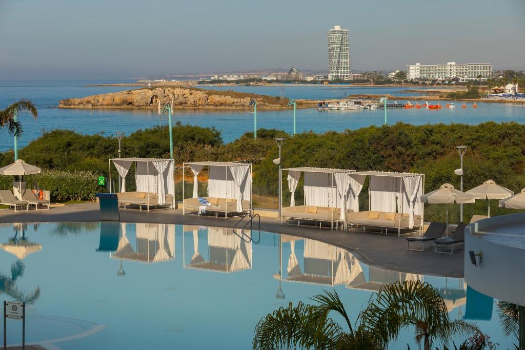 a hotel swimming pool with a view of the ocean at NissiBlu Beach Resort in Ayia Napa