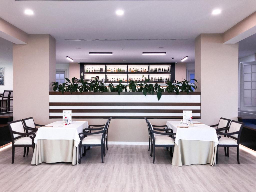 a dining room with tables and chairs and plants at Rixos-Prykarpattya Resort in Truskavets