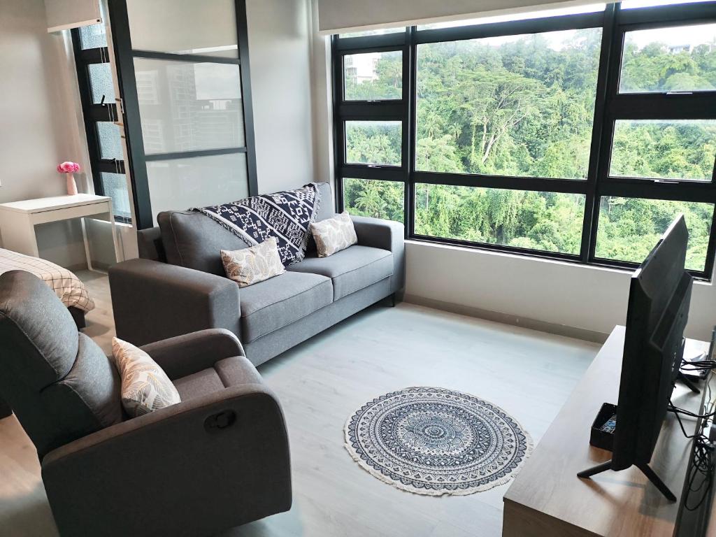 a living room with a couch and a tv at City View with Jesselton Quay Near Suria Sabah Mall & Jesselton Point in Kota Kinabalu