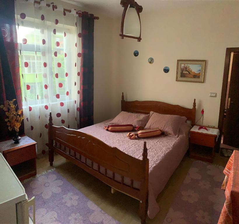 - une chambre avec un lit en bois et une fenêtre dans l'établissement Topciu's Lake Appartments, à Pogradec